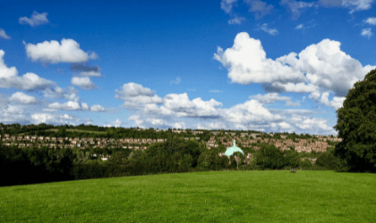 The view from a hill of a sprawling town in the English countryside.