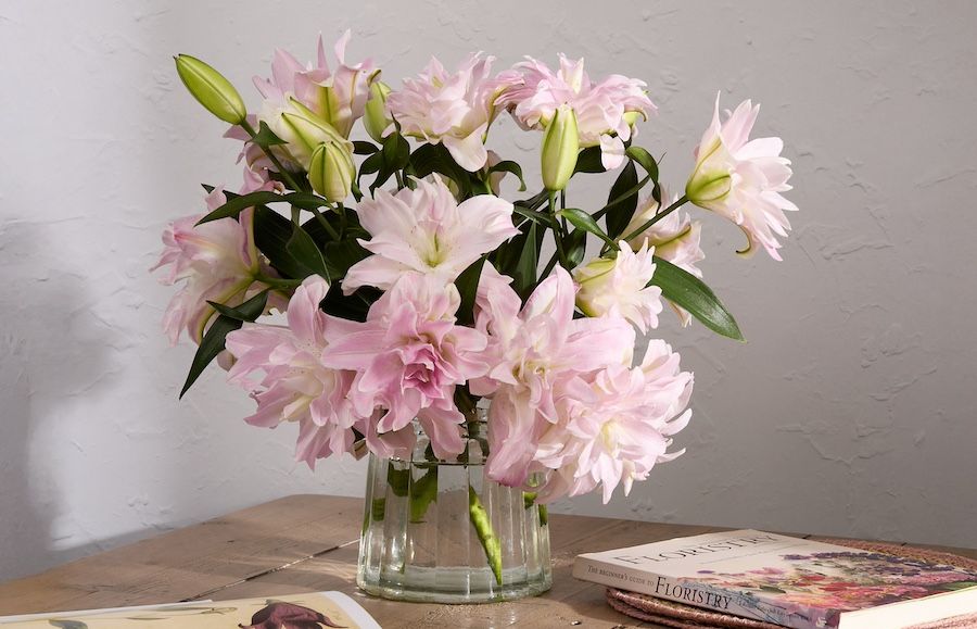 A bouquet of pink lilies in a glass vase