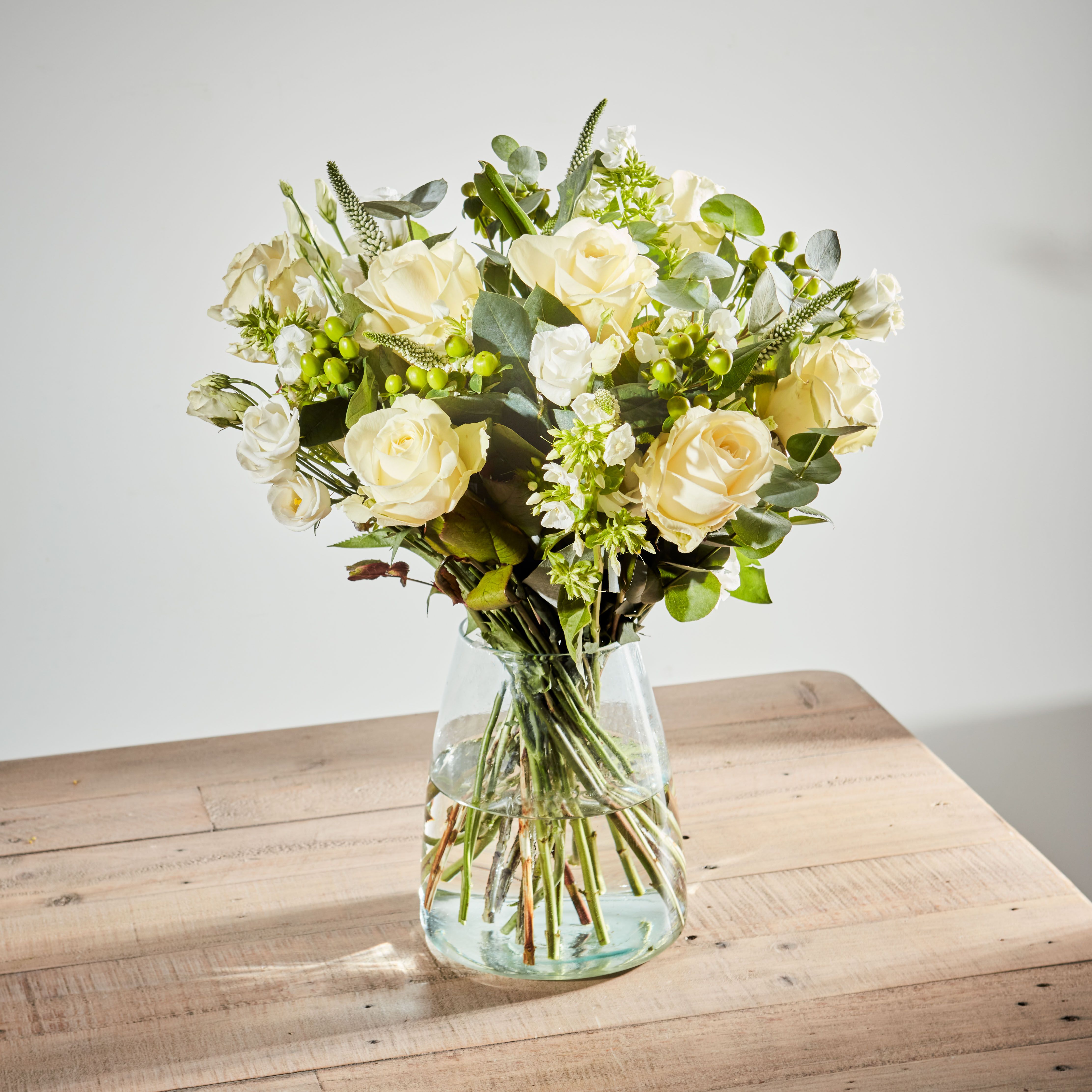 White Avalanche roses, white lisianthus, green hypericum, white veronica, white phlox, eucalyptus cinerea, and leucothoe foliage.