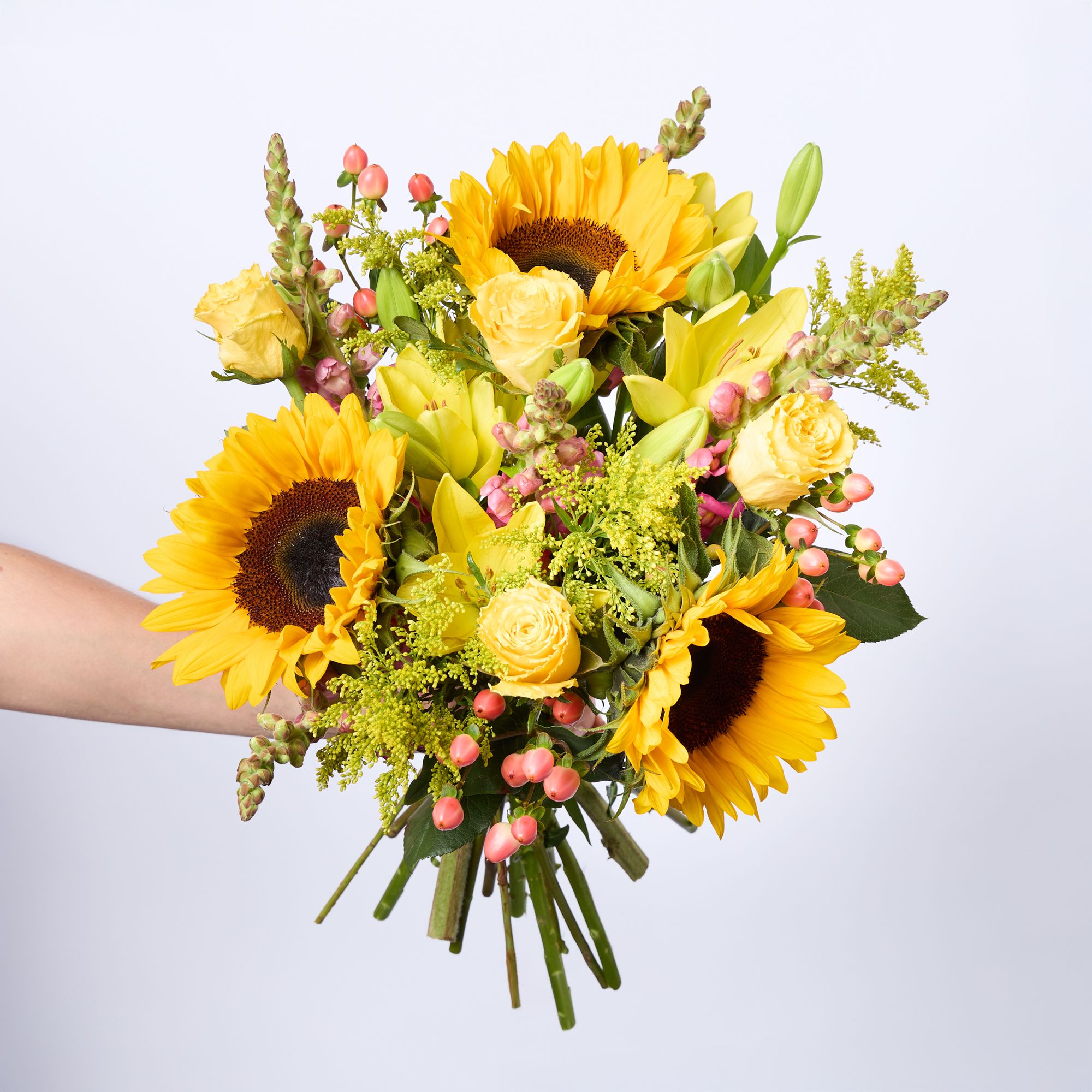 Sunflowers, yellow LA lilies, yellow roses, pink antirrhinum, peach hypericum, and solidago