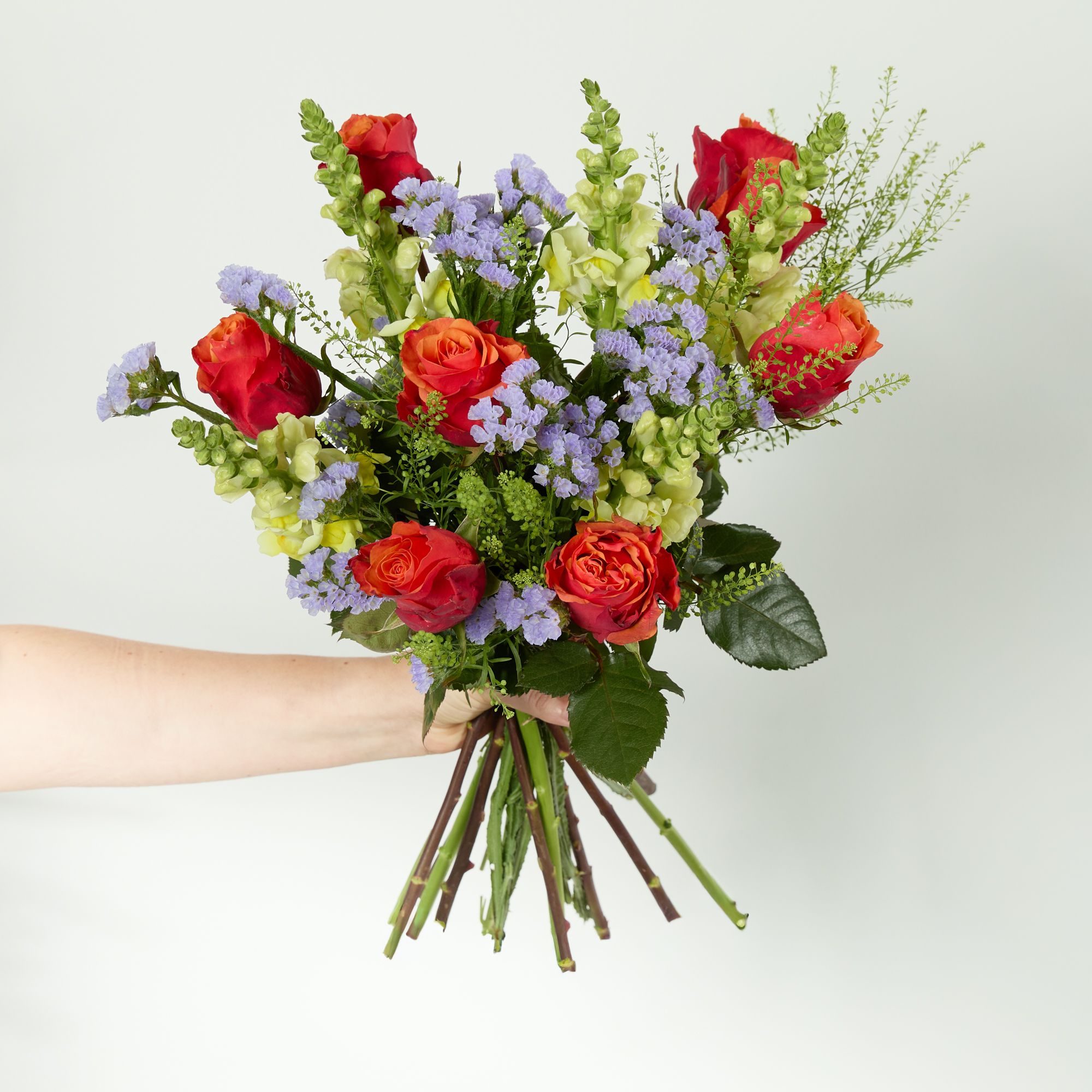 Red roses, yellow antirrhinum, purple solidago and greenbell 