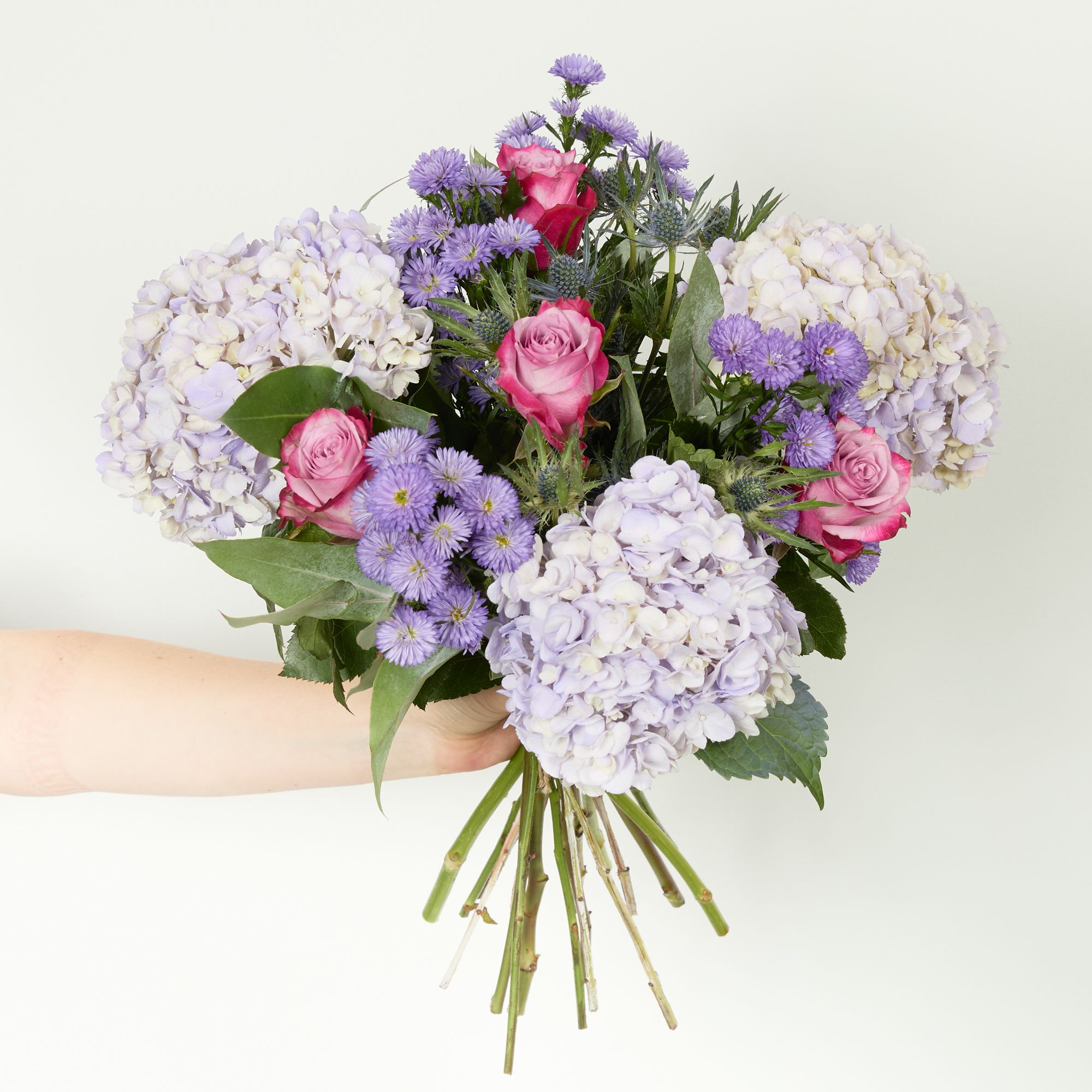 Lilac hydrangeas, 'Deep Purple' roses, lilac asters, blue eryngium and eucalyptus robusta