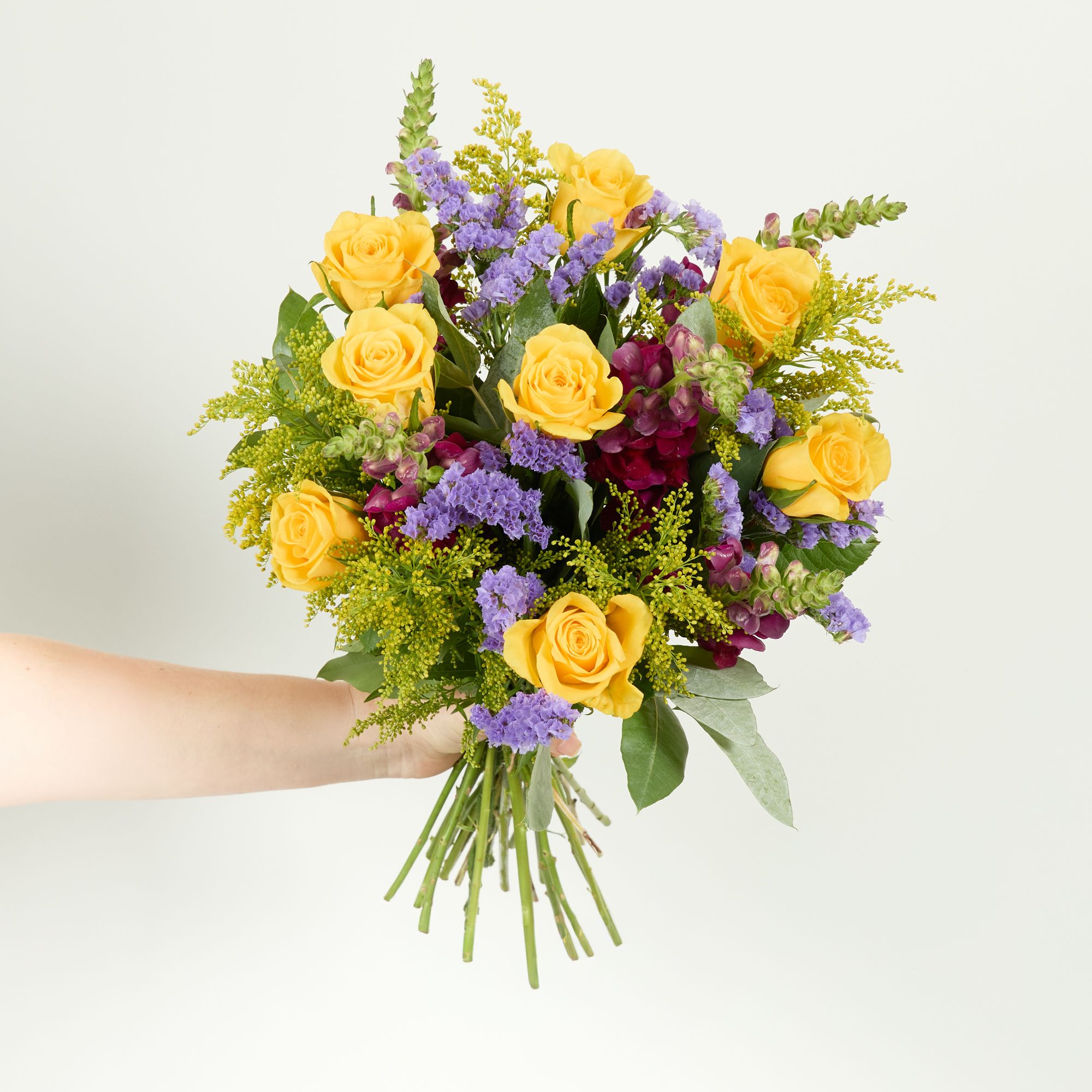 Yellow roses, burgundy antirrhinum, purple statice and solidago and eucalyptus robusta