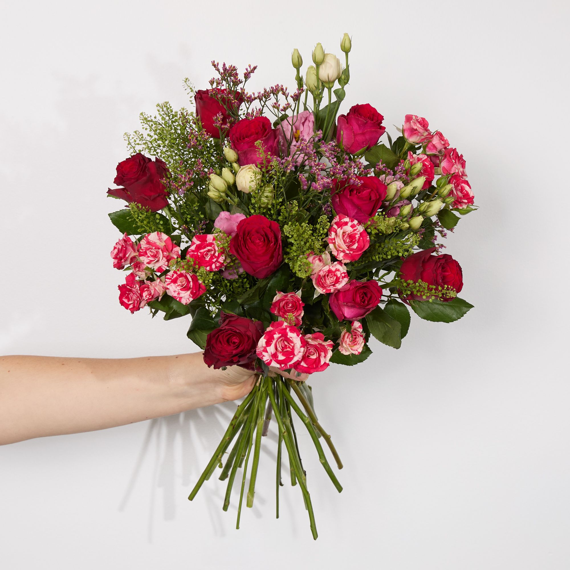 Cerise roses, ‘Fireworks’ spray roses, red roses, pink lisianthus, pink limonium, greenbell