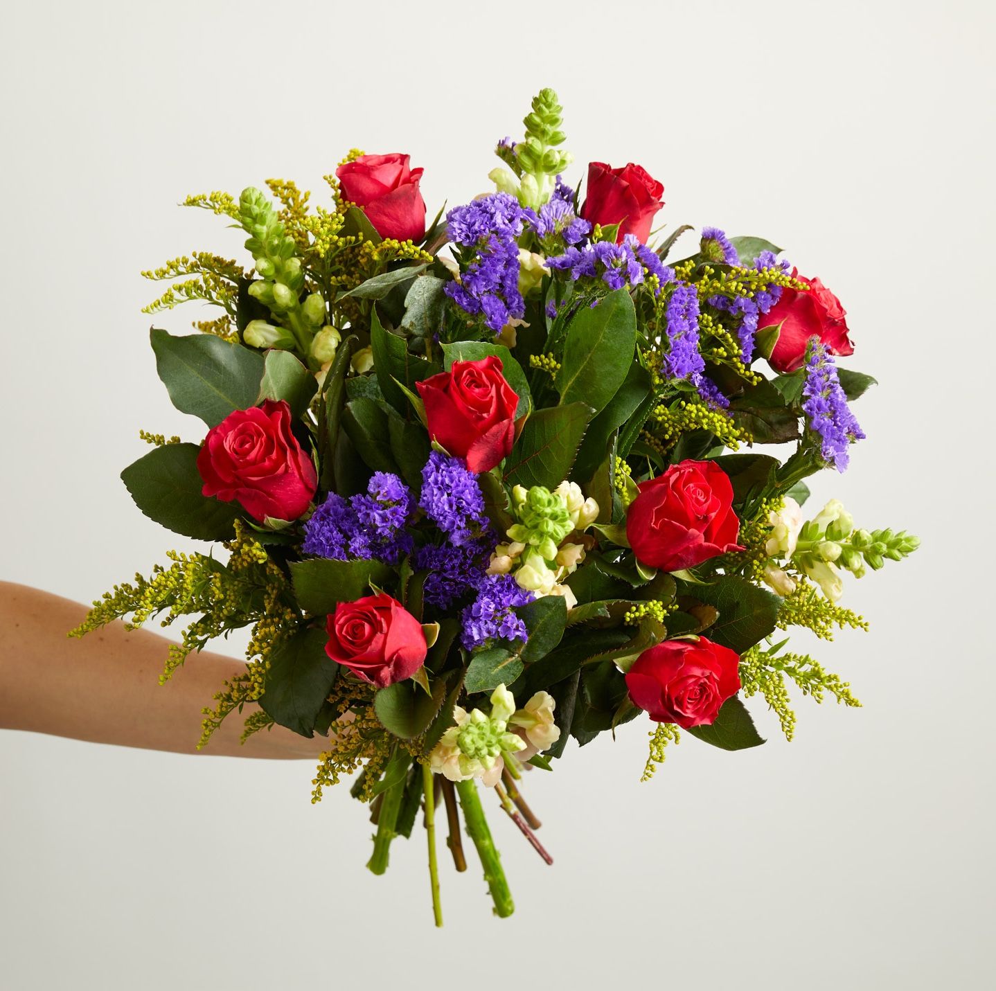 Cerise roses, blue statice, pink antirrhinum, solidago and eucalyptus robusta