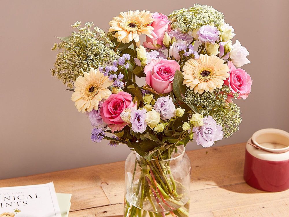 A bouquet of cream Gerberas, with pink roses, lilac Lisianthus and Statice, and white and green Ammi Majus