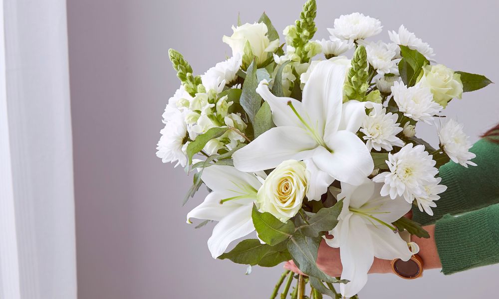 Photo of the Serenity bouquet - white oriental lilies, white roses, white chrysanthemum, white antirrhinums and green eucalyptus.